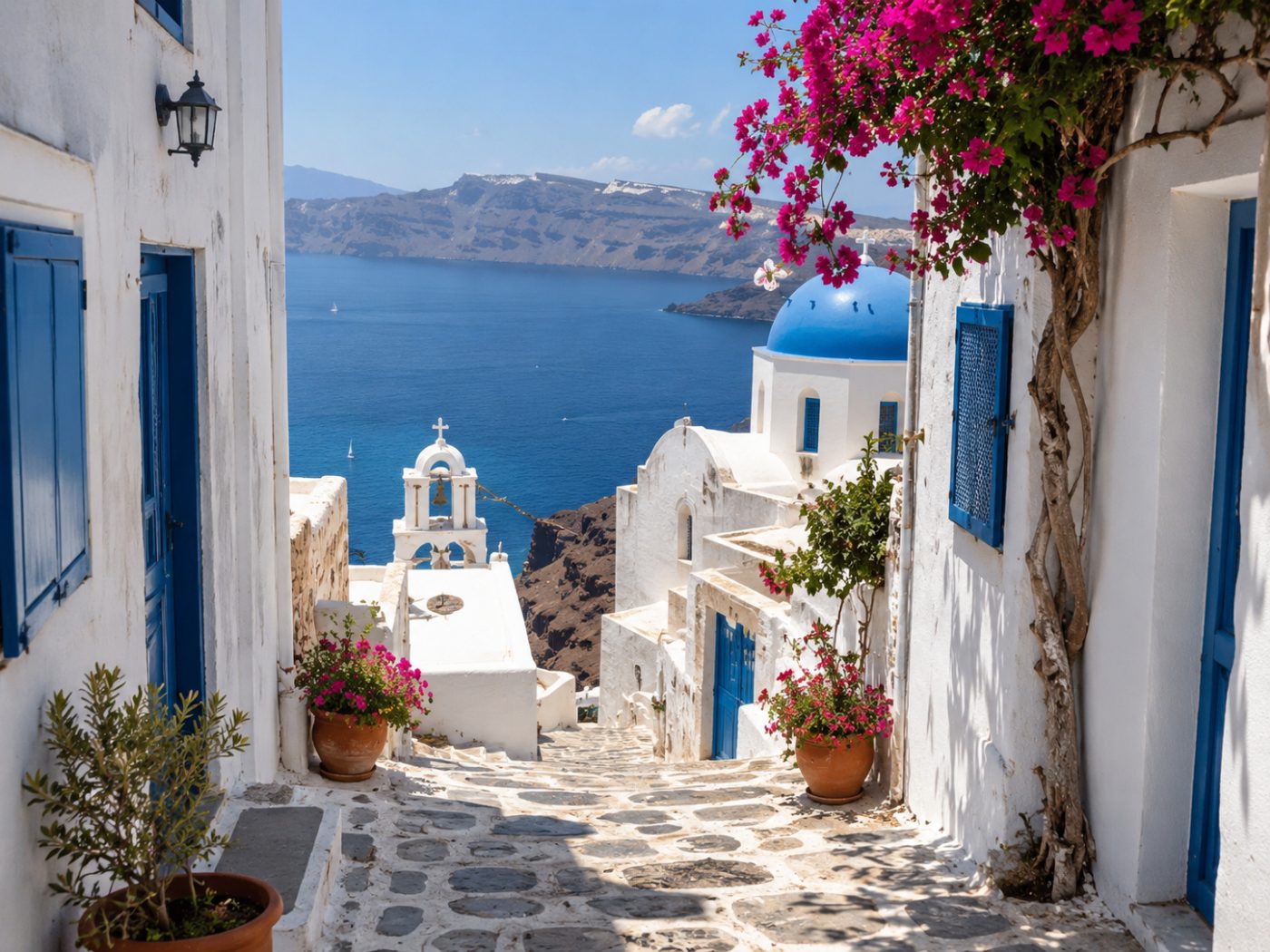 Vicolo greco con cupola blu e mare, immagine simbolica della prossima meta di Essenza in Viaggio